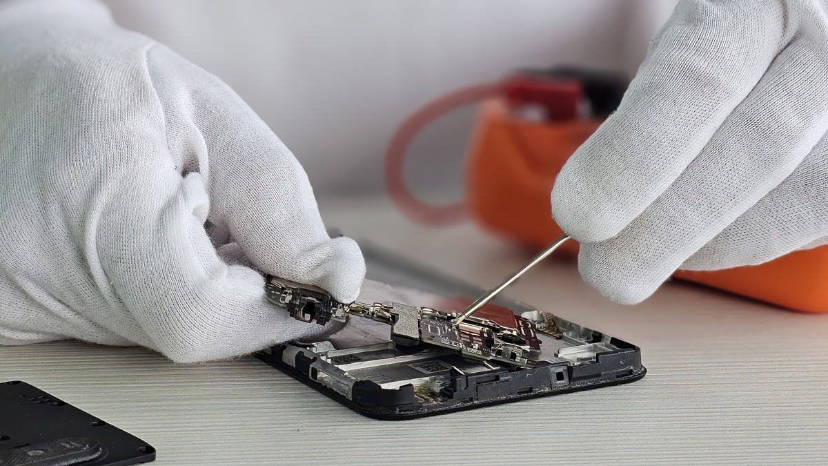 Tecnico in guanti bianchi ripara smartphone